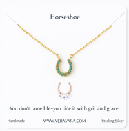 Gold horseshoe necklace with turquoise stones on a white background, featuring a quote and Veravara branding.